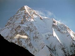 25 K2 Just After Sunrise From Concordia K2 shines in the early morning light from Concordia. The upper part of the K2 Southwest Pillar catches a bit of sun separating the west face in shadow from the sun descending the K2 South Face. The South-southeast Spur is partially in the sun and arrives at the K2 Shoulder on the right. On the far right is the Abruzzi Ridge / Spur, the East-southeast ridge, the normal ascent route. Called a suicidal route by Reinhold Messner, the K2 South Face or Polish Line was climbed for the first time on July 7, 1986 by Jerzy Kukuczka and Tadeusz Piotrowski. Piotrowski fell to his death on the descent.